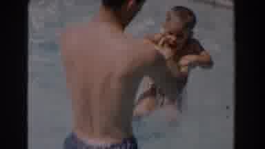 Van Nuys California (1962): A Man In Shorts Plays With His Son In The Pool Having