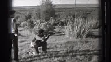 Washington (1939): Person Aims Rifle In Field On A Clear Day