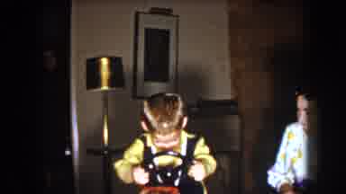 North Hollywood California-1961: Young Caucasian Boy In A Yellow Collared Shirt Playing With Toy Steering Wheel
