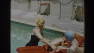 North Hollywood California (1961): A Woman Guides Her Son On How To Swim Using A