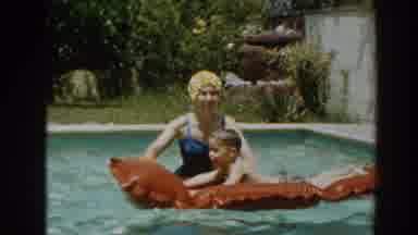 North Hollywood California (1961): A Woman Guides Her Son On How To Swim Using A