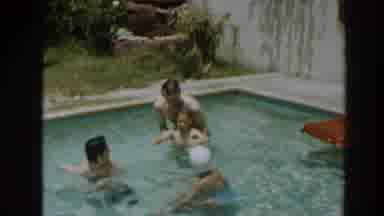 North Hollywood California (1961): Man Wearing Black Shorts Helps Small Boy To