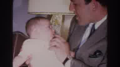 Madison Wisconsin (1966): Baby Wearing White Shirt Tries Tickling Man Wearing Grey