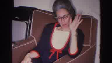 Madison Wisconsin (1966): Woman Wearing Black Dress And Glasses Sits In Brown