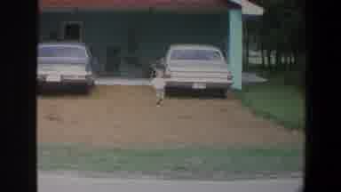 Minnesota (1973): Toddler Wearing Green Shorts Runs Towards Camera On A Clear Day