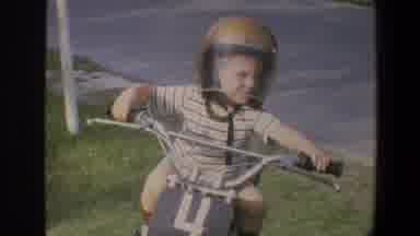 Minnesota (1973): Little Boy Wearing A Helmet Playing On A Bike That Mimics A