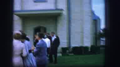 Moberly Missouri-1962: Small Crowd Standing Near Tan And Grey Building On A