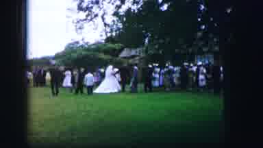 Moberly Missouri (1962): Woman In White Wedding Gown Walks Across Lawn As Line Of