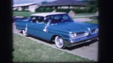 Moberly Missouri (1962): Girl Wearing White Dress Near Blue Pontiac As It Pulls