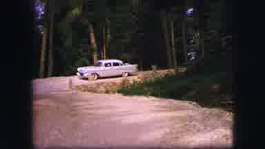 Saint Moritz Switzerland (1963): View Of Grey Car Turning Onto Dirt Road With