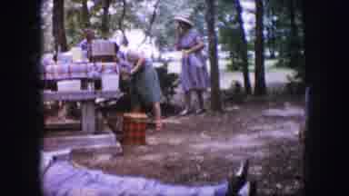 Dallas Texas (1964): Woman Wearing Green Skirt Stands Near Red Checked Picnic