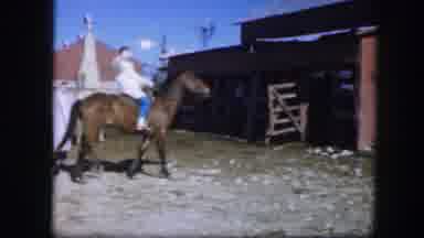 Fort Worth Texas (1964): Woman Wearing White Coat Waves At Camera While Riding
