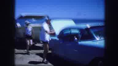 Fort Worth Texas (1964): Person Wearing White Hat Walks To Blue Car On A Bright