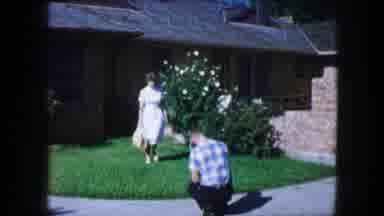 Lewisville Texas (1965): Woman Wearing White Dress Walks Towards Man Wearing Black