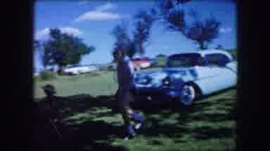 Lewisville Texas (1965): Woman Wearing White Shirt Walks To Man Sitting In White
