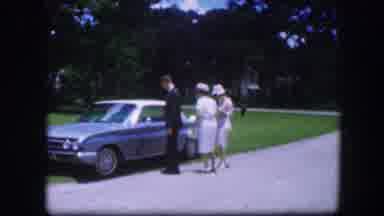 Kirksville Missouri (1967): Man Wearing Grey Suit Opens Door To Blue Car On A