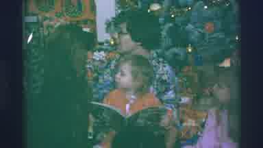 Blue Springs Missouri-1973: Family Sits In Front Of Christmas Tree While Child Reads Book