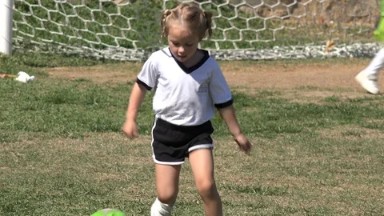 LOS CABOS MEXICO-2019: Little Blond Girl Playing Football On The Field Just