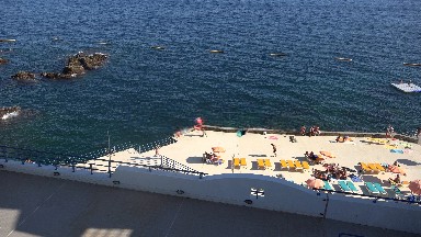 MADIERA PORTUGAL-2016: A Building On The Ocean's Shore With Waves And Rocks