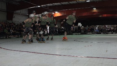 DENVER COLORADO-2015: One Team Of Ladies In Green And Black Outfits Warm Up For Roller Derby Match
