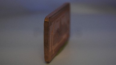 A Rolling Vintage Golden Brown Rectangular One Hundred Dollar Coin
