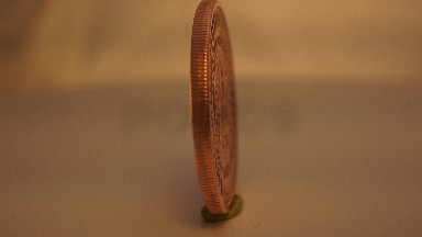 A Golden Coin With Some Carvings On It Is Rotating Around In A Circle