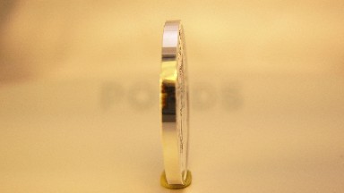 Foreign Gold Coin Rotating Being Displayed With A Blurred Background
