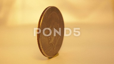 A United States Currency Quarter Spins Around In Very Slow Motion