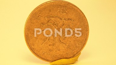 Closeup Of Copper Penny Turning In Front Of A Simple Pale Background