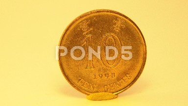 Standing Ten Cents Golden Coin Rotating Slowly With Yellow Background