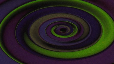 A Background Of Green And Purple Swirls That Are Rotating Around In A Circle