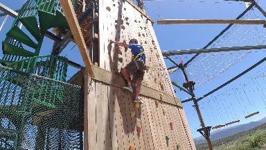 WINTER PARK COLORADO-2019: A Man Climbing Up An Outdoor Rock Wall In A Harness