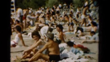 1954: Holidays Xmas Caucasian. A Group Of People Sitting On Top Of A Sandy
