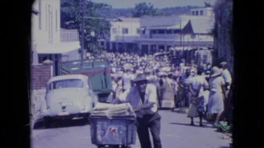 1966: Kingston Jamaica. A Man Standing Next To A Garbage Can On A Street.
