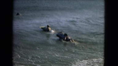 1967: New Mexico Usa. A Couple Of People Riding Surfboards On Top Of A Wave.