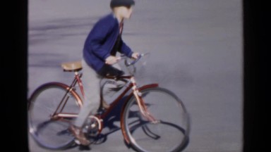 1957: Birmingham Alabama. A Man Riding A Bike Down A Street.