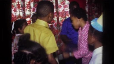 1976: Harlem, New York, USA. A Group Of People Standing Around In A Room.