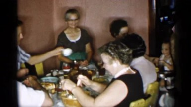 1955: A Group Of People Sitting Around A Table Eating Food.