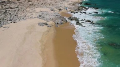 BUZZARDS BEACH EAST CAPE BCS MEXICO-2023: Aerial View Of A Sandy Beach Next To Turquoise Waters