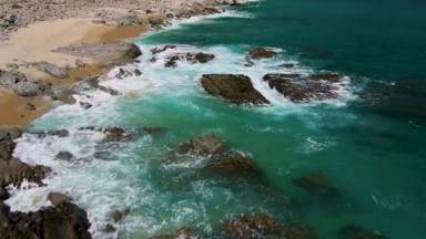 BUZZARDS BEACH EAST CAPE BCS MEXICO-2023: A Body of Water Next to a Rocky Shore