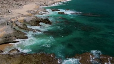 BUZZARDS BEACH EAST CAPE BCS MEXICO-2023: A Large Body Of Water Next To A Rocky Coastline