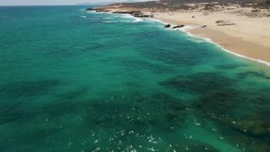 BUZZARDS BEACH EAST CAPE BCS MEXICO-2023: An Aerial View Of A Beach With Clear Waters And Golden Sand