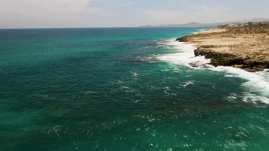 BUZZARDS BEACH EAST CAPE BCS MEXICO-2023: A Large Body Of Water Next To A Rocky Coastline