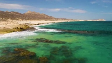 BUZZARDS BEACH EAST CAPE BCS MEXICO-2023: A Large Body Of Water Next To A Sandy Beach