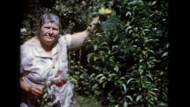 1960: Wauconda, IL. USA. Woman standing in a field holding a orange