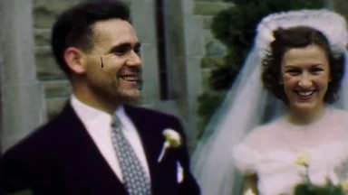 1950: Bride and Groom in Formal Wedding Attire Standing in Front of a Stone