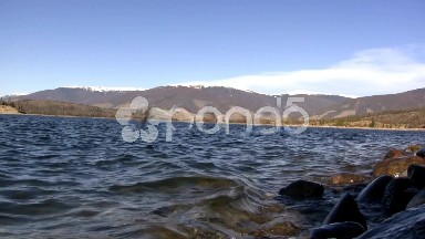 (Seamless Loop) Lake Shore Waves With Mountain Backdrop