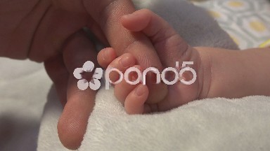 Newborn Baby Squeezing Dad's Hand