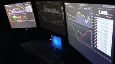London United Kingdom: Three Computer Screens of Bitcoin Traders