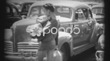 (1940's 8mm Vintage) Man Carrying Packages Across Parked Cars